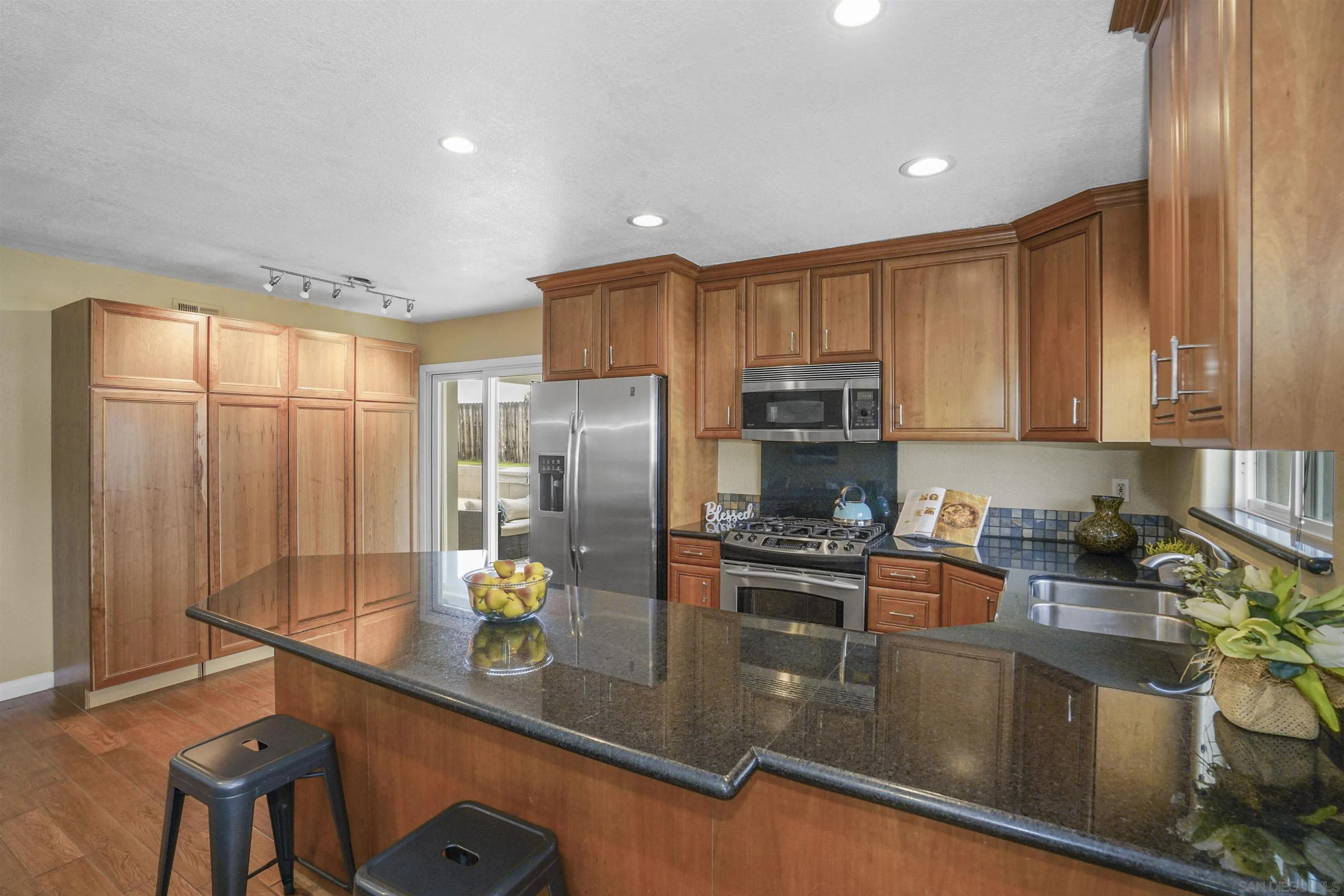 10111 White Pine Lane Santee, CA 92071 - Photo 12 of 35 a kitchen with stainless steel appliances granite countertop a refrigerator a stove and a sink with wooden floor