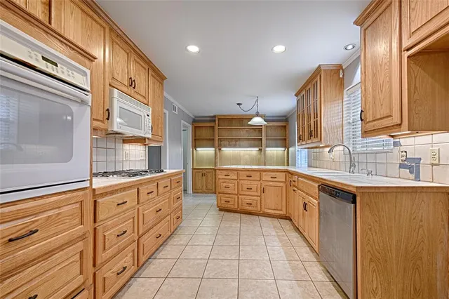 a large kitchen with stainless steel appliances granite countertop a sink and cabinets