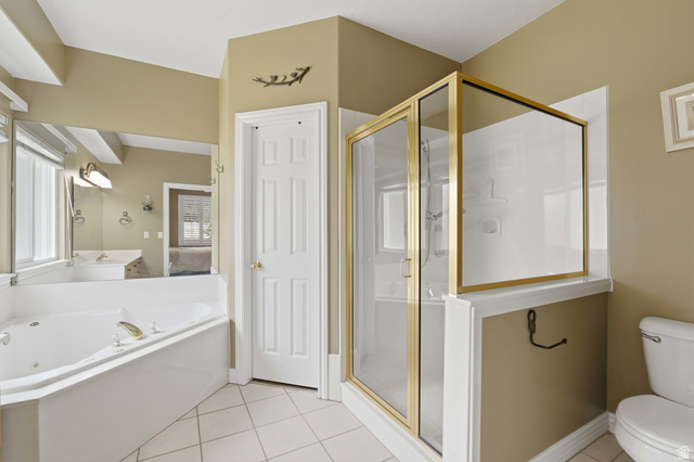 11811 Cottage View Lane Draper, UT 84020 - Photo 8 of 25 Bathroom featuring a corner jetted tub, a separate shower enclosure with brass-finish framing, white tile flooring, and a six-panel interior door