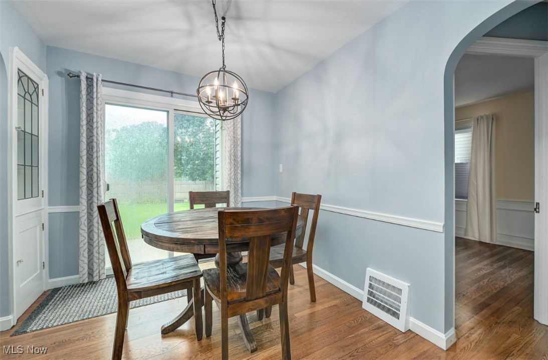 16501 Munn Road Cleveland, OH 44111 - Photo 15 of 42 Dining room featuring wood finished floors, arched walkways, and a chandelier