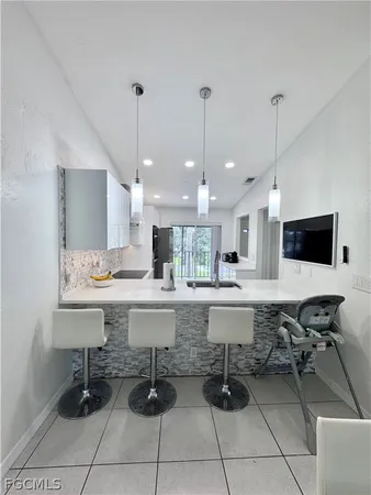 a view of a kitchen with kitchen island granite countertop a table and chairs in it