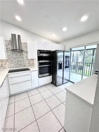 a kitchen with stainless steel appliances kitchen island granite countertop a refrigerator and a sink