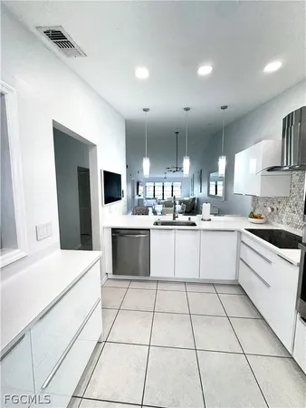 a large white kitchen with a white cabinets and a fireplace