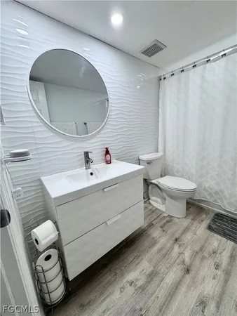 a bathroom with a sink mirror and toilet