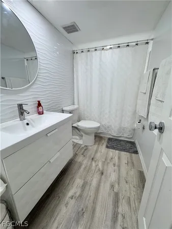 a bathroom with a sink a toilet and shower curtain