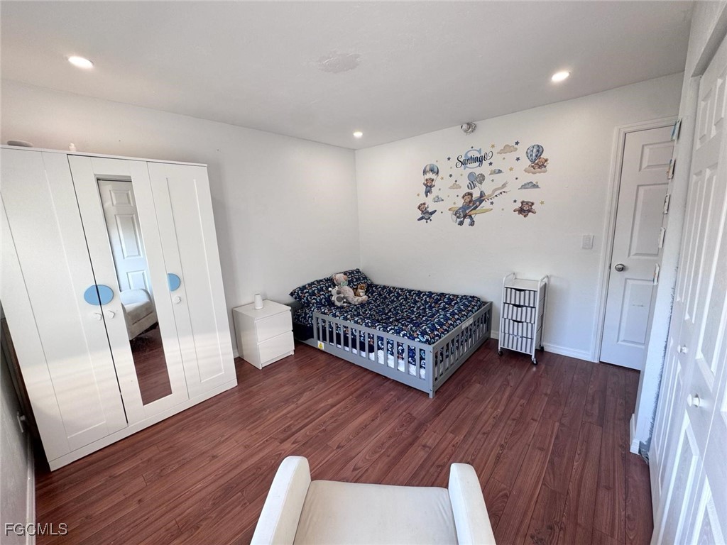 4079 Northlight Drive, Unit 1802 Naples, FL 34112 - Photo 23 of 29 a bedroom with a bed and wooden floor