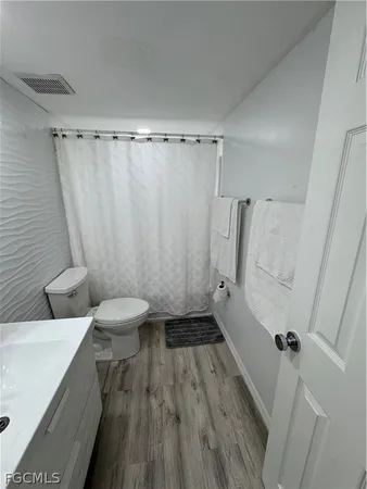 a bathroom with a sink mirror vanity and toilet