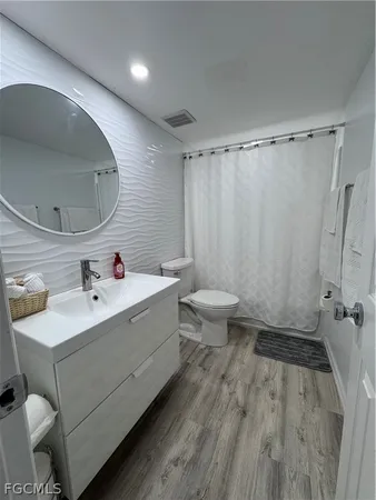 a bathroom with a sink a toilet and shower