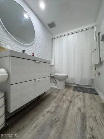 a kitchen with a refrigerator and white cabinets
