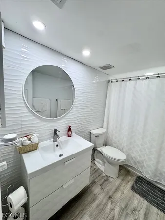 a bathroom with a sink mirror vanity and toilet
