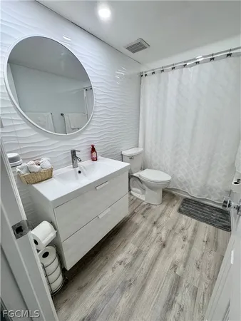 a bathroom with a sink mirror vanity and toilet