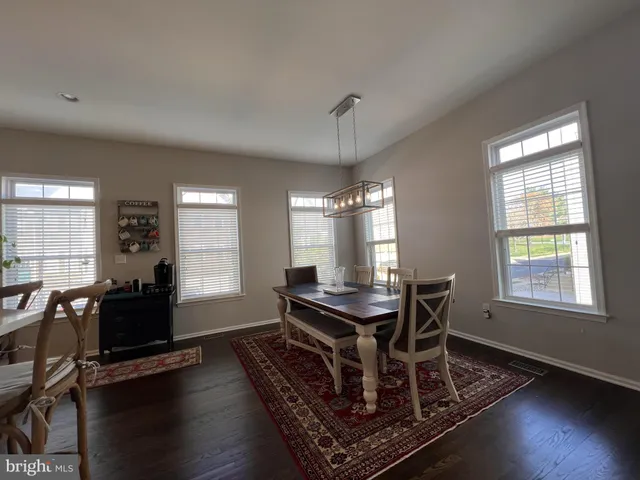 a open kitchen with stainless steel appliances granite countertop a refrigerator dining table and chairs