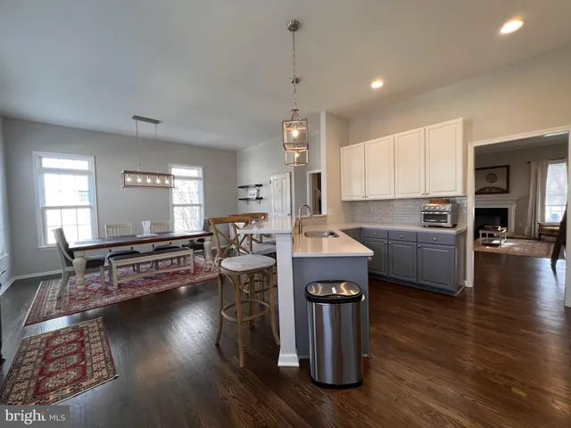 a kitchen with stainless steel appliances granite countertop a refrigerator a stove a sink and white cabinets