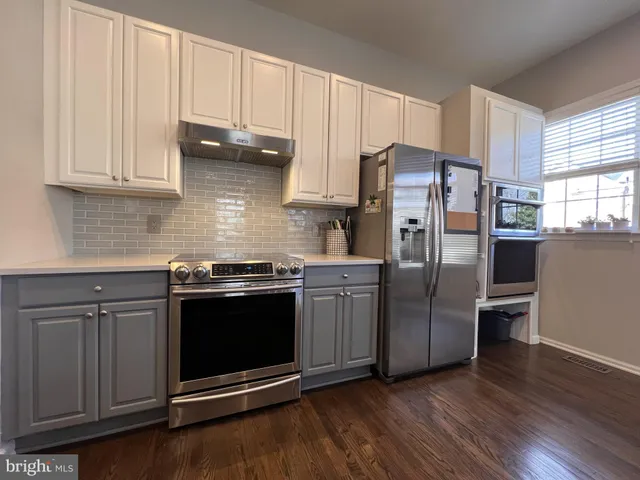 a bedroom with a bed and a flat tv screen on dresser