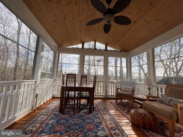 a spacious bedroom with a bed a chandelier and a flat screen television