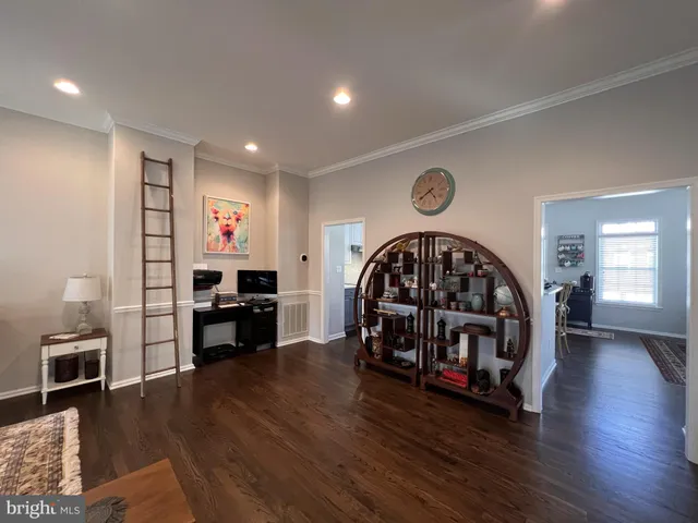 a view of a dining room and livingroom with furniture wooden floor a rug and a chandelier