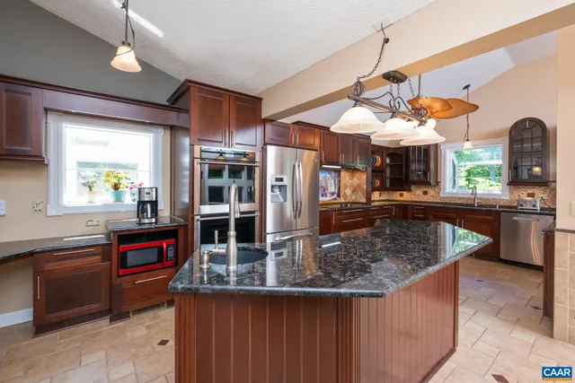a kitchen with stainless steel appliances granite countertop a stove refrigerator and cabinets