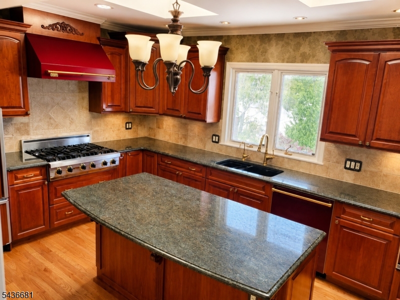 178 East Lindsley Road, Unit 2 Cedar Grove, NJ 07009 - Photo 4 of 28 a kitchen with stainless steel appliances granite countertop a sink a stove and wooden cabinets