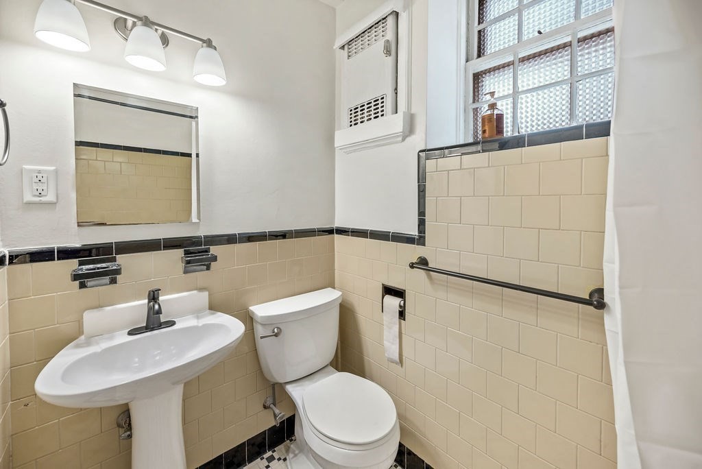 56 Elm Street, Unit 1 Worcester, MA 01609 - Photo 16 of 22 a white toilet sitting next to a bathroom sink