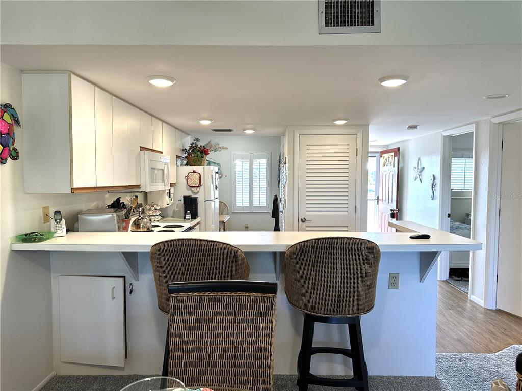 6800 Placida Road, Unit 163 Englewood, FL 34224 - Photo 11 of 24 a view of kitchen with stainless steel appliances granite countertop sink stove dining table and chairs