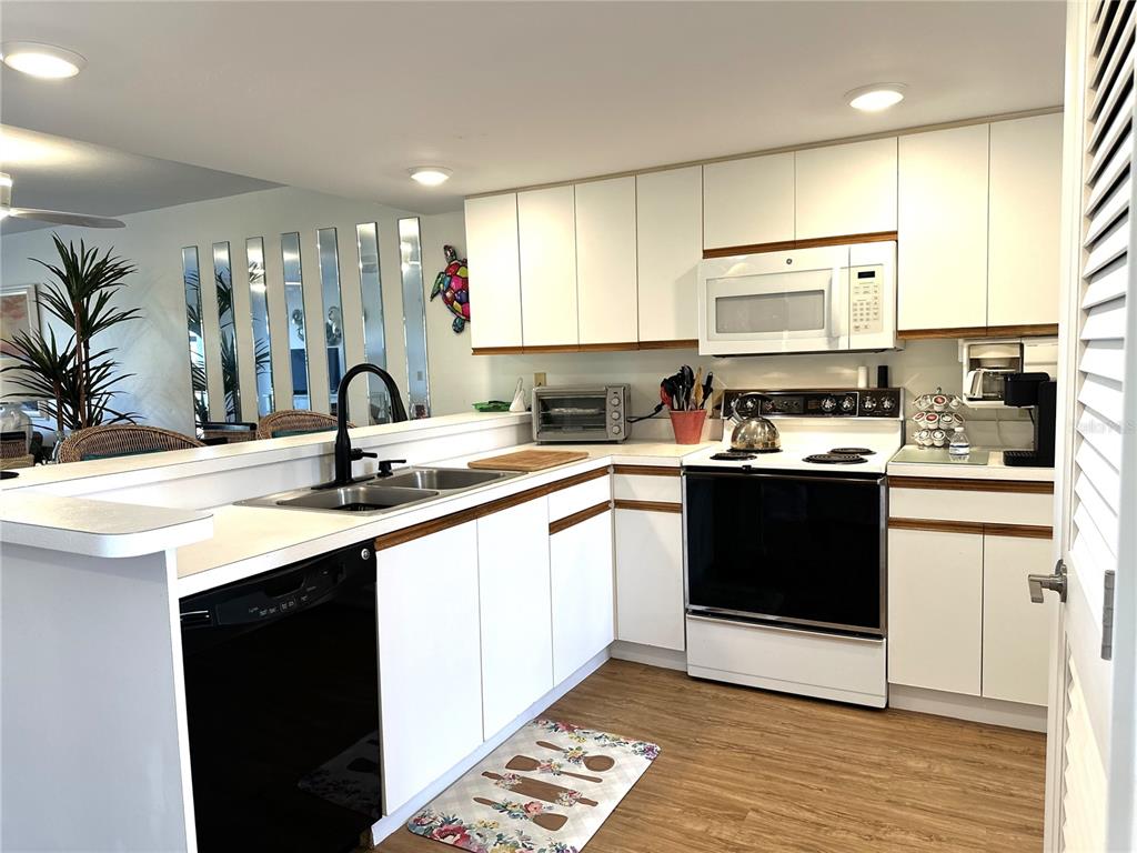 6800 Placida Road, Unit 163 Englewood, FL 34224 - Photo 7 of 24 a kitchen with a sink stove and cabinets