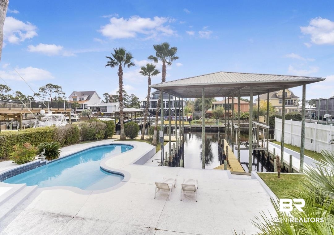 26318 Marina Road Orange Beach, AL 36561 - Photo 2 of 38 View of pool featuring boat lift, a dock, and a water view