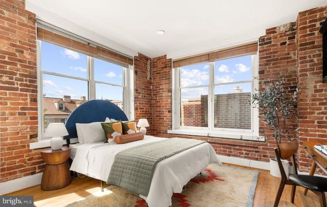 a bedroom with a bed and a large window