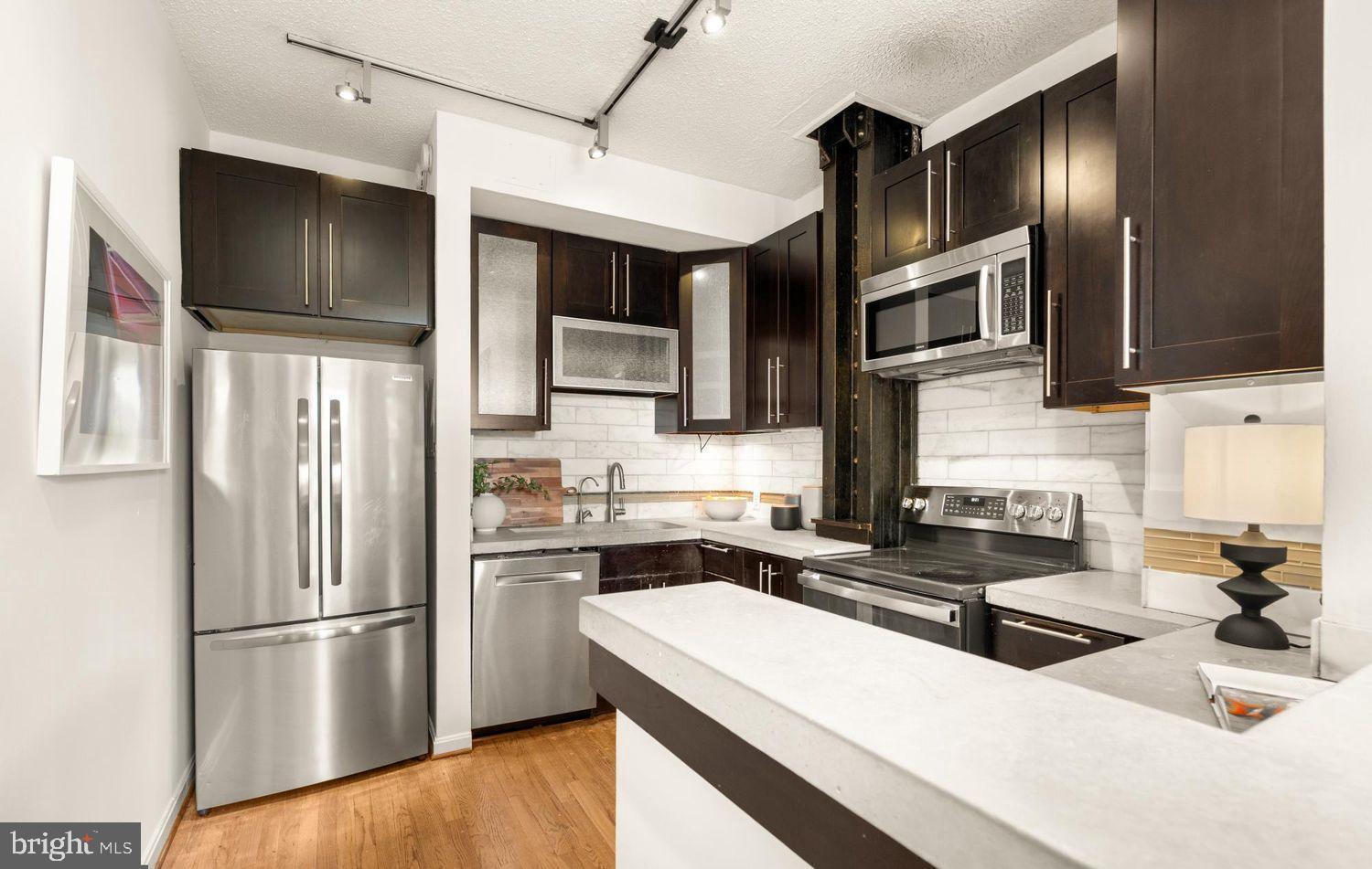 1615 Q Street Northwest, Unit 301/303 Washington, DC 20009 - Photo 9 of 53 a kitchen with stainless steel appliances granite countertop a refrigerator a stove a sink and a microwave
