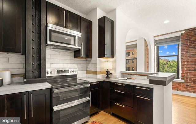 a kitchen with stainless steel appliances a sink stove and cabinets