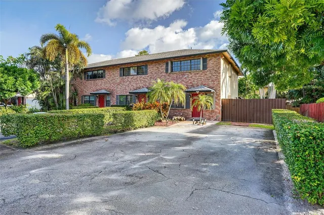 a view of a house with a yard and a large tree