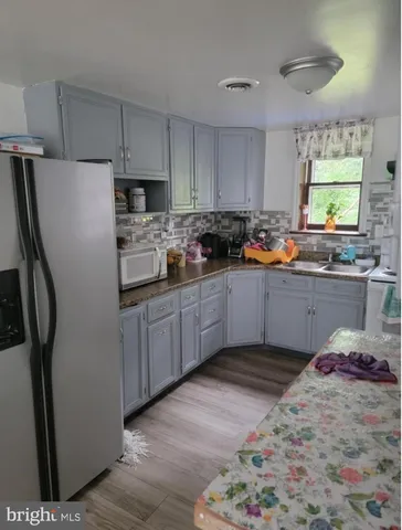 a kitchen with stainless steel appliances granite countertop a refrigerator sink and stove