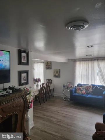 a living room with furniture a flat screen tv and a window