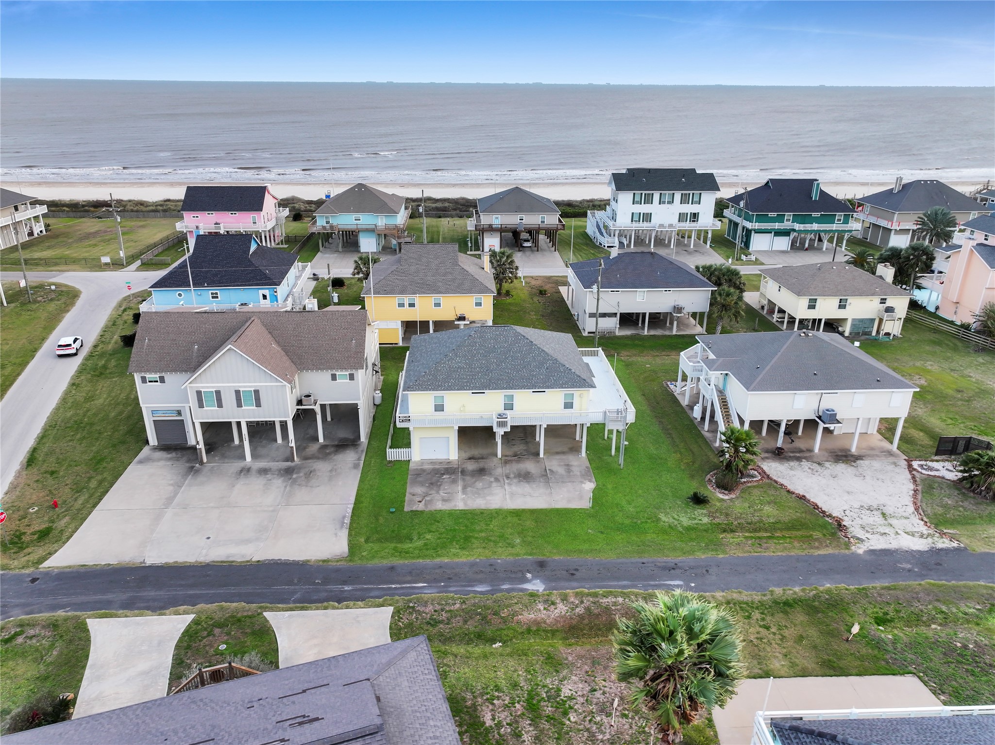 an aerial view of residential houses with outdoor space and parking