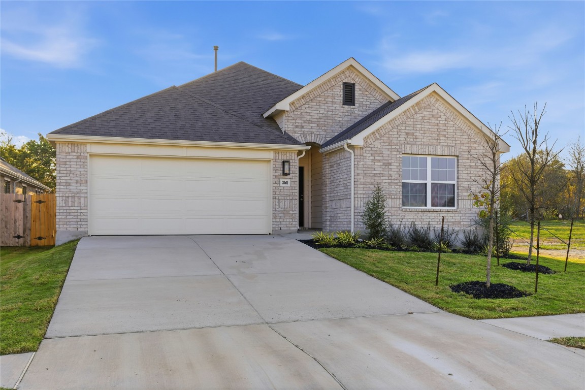 350 Mustang Bend Kyle, TX 78640 - Photo 2 of 18 Ranch-style house with brick siding, concrete driveway, an attached garage, and roof with shingles