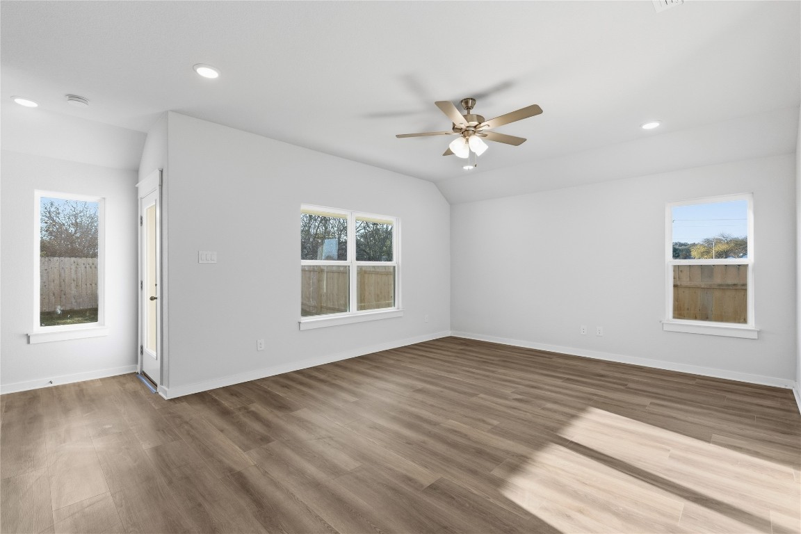 350 Mustang Bend Kyle, TX 78640 - Photo 7 of 18 Unfurnished room featuring wood finished floors, lofted ceiling, a ceiling fan, and recessed lighting