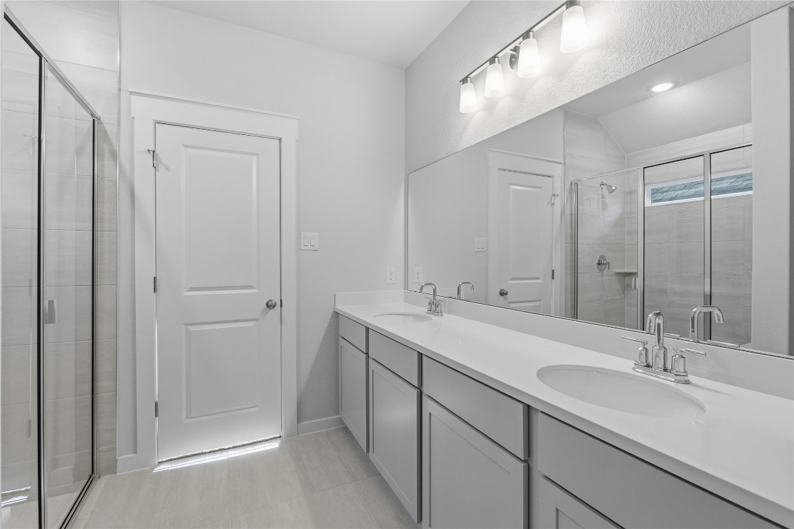 350 Mustang Bend Kyle, TX 78640 - Photo 10 of 18 Bathroom with double vanity, a stall shower, and recessed lighting