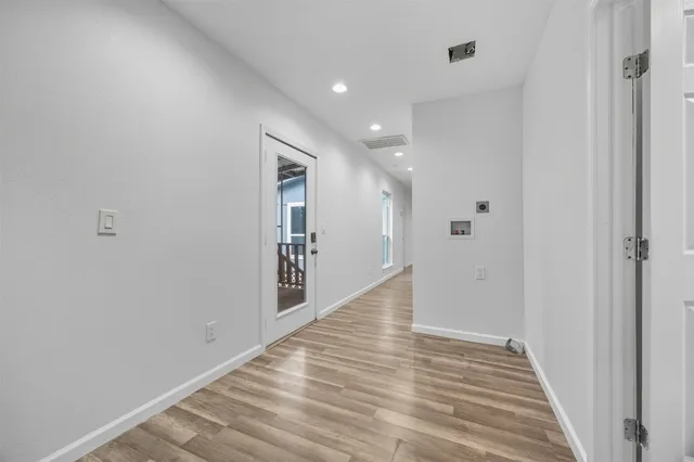 an empty room with wooden floor and windows