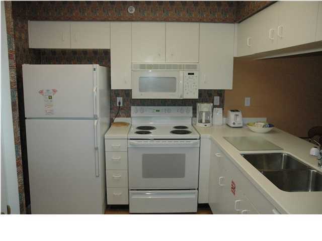 10254 East Hwy Inlet Beach, Unit 13W 30A Inlet Beach, FL 32461 - Photo 7 of 16 a kitchen with a refrigerator sink stove and cabinets