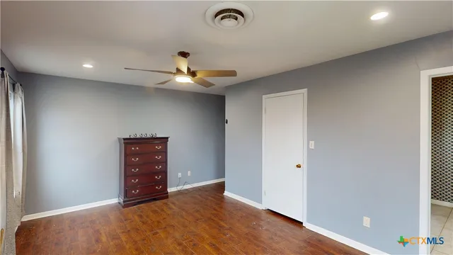 a view of hallway with livingroom and wooden floor