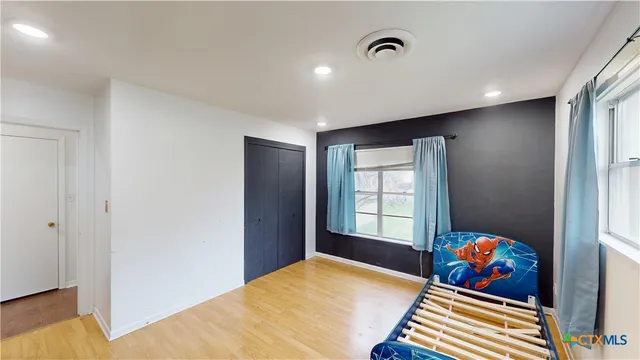 a front view of a house with a garden and trees