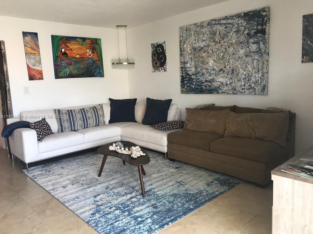 320 South Surf Road, Unit 305 Hollywood, FL 33019 - Photo 4 of 32 a living room with furniture and a rug