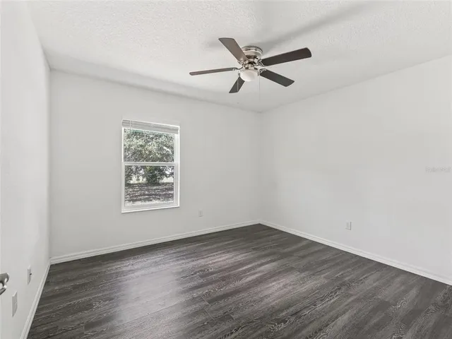 a view of a big room with wooden floor and windows