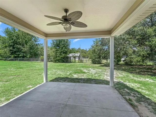 a view of a porch with furniture and a yard