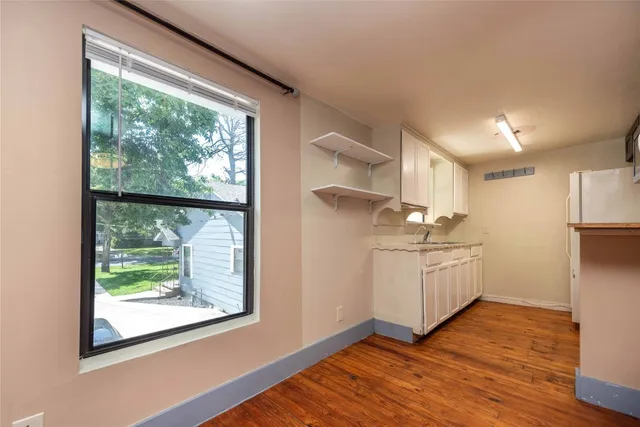 a kitchen with wooden floors and white walls