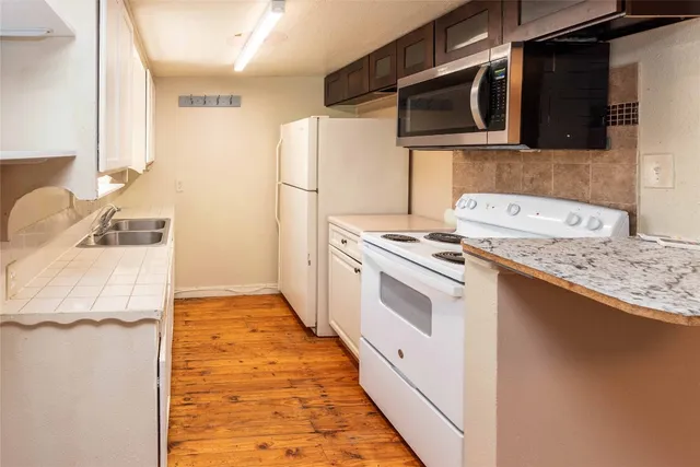 a kitchen with stainless steel appliances a stove microwave and refrigerator