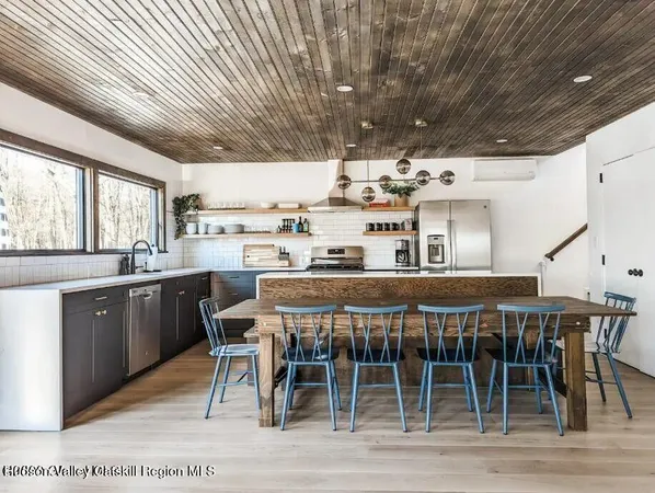 a kitchen with stainless steel appliances granite countertop a dining table chairs and granite counter tops