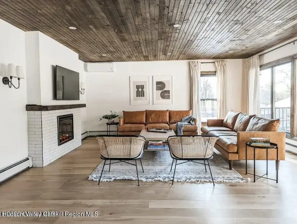 a living room with fireplace furniture and a wooden floor