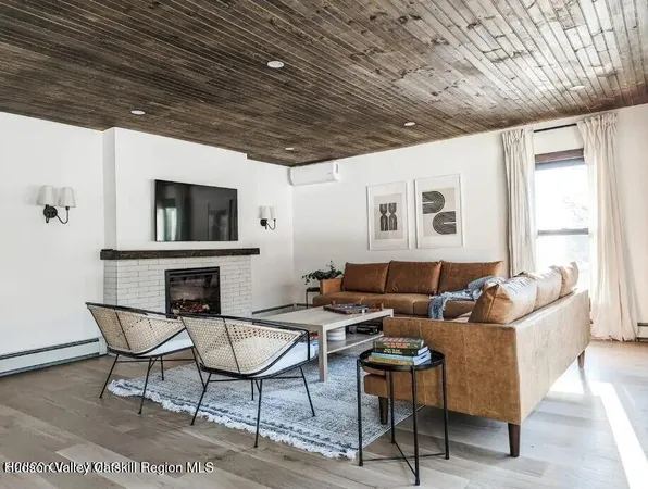 a living room with furniture a flat screen tv and a table