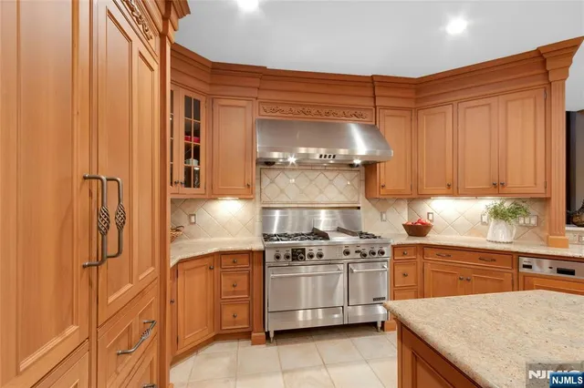 a large kitchen with kitchen island a sink appliances and a counter top space