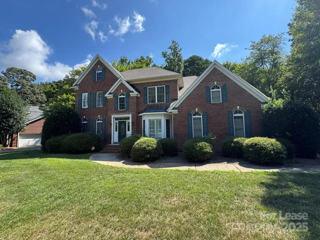 a front view of a house with a garden and yard